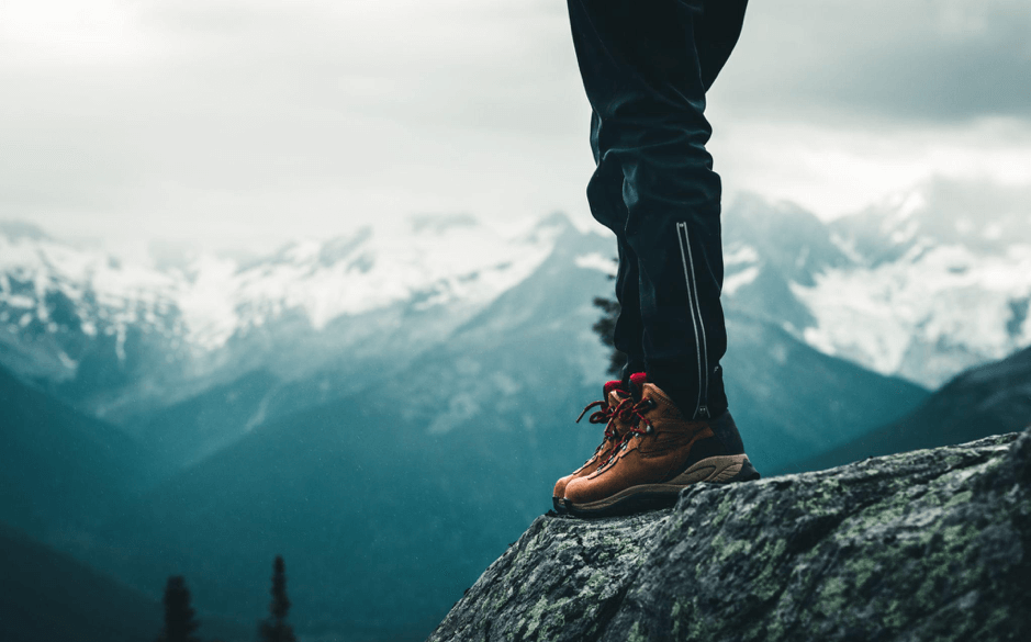 man wearing hiking boots on mountain