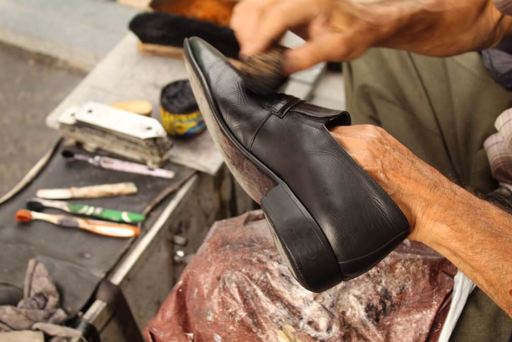 shoe care professional brushing dress shoe